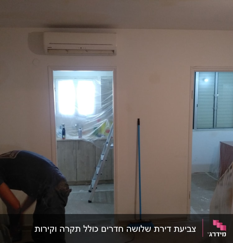 אדם צובע קיר, סולם וחומרי צביעה